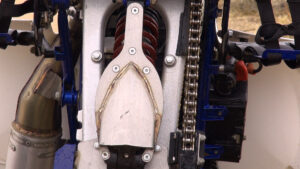 Underside view of Honda 400EX showing Teixeira Tech rear linkage and stainless steel swingarm skid plate.