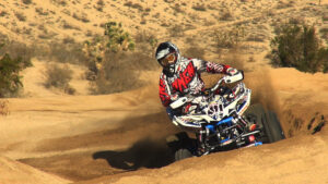 Honda 400EX carving a sandy corner with Teixeira Tech A-arms and TRX450R rear suspension.