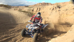 Honda 400EX navigating S-curves through a deep sandy wash during cross-country testing.