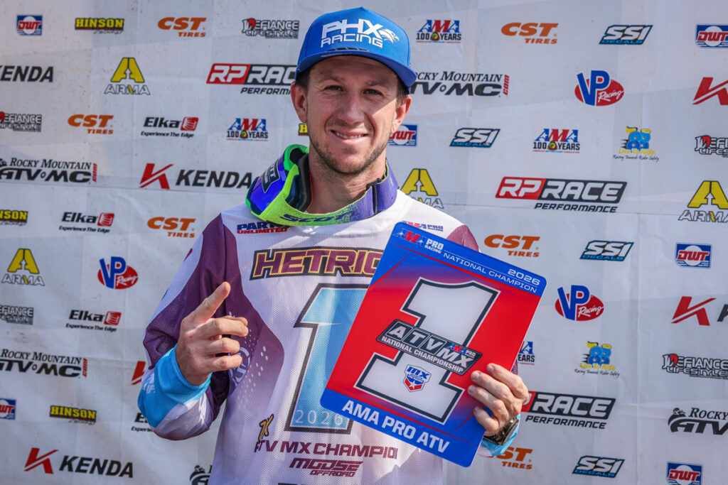 Joel Hetrick on the podium holding the number one plate after clinching the 2026 AMA Pro ATV Motocross National Championship.