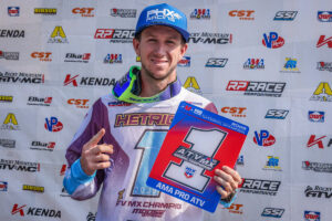 Joel Hetrick on the podium holding the number one plate after clinching the 2026 AMA Pro ATV Motocross National Championship.