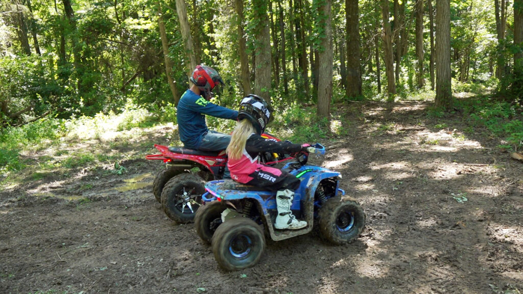 Young rider testing the Denago E-Hawk 6 electric youth ATV on grass and light off-road terrain.