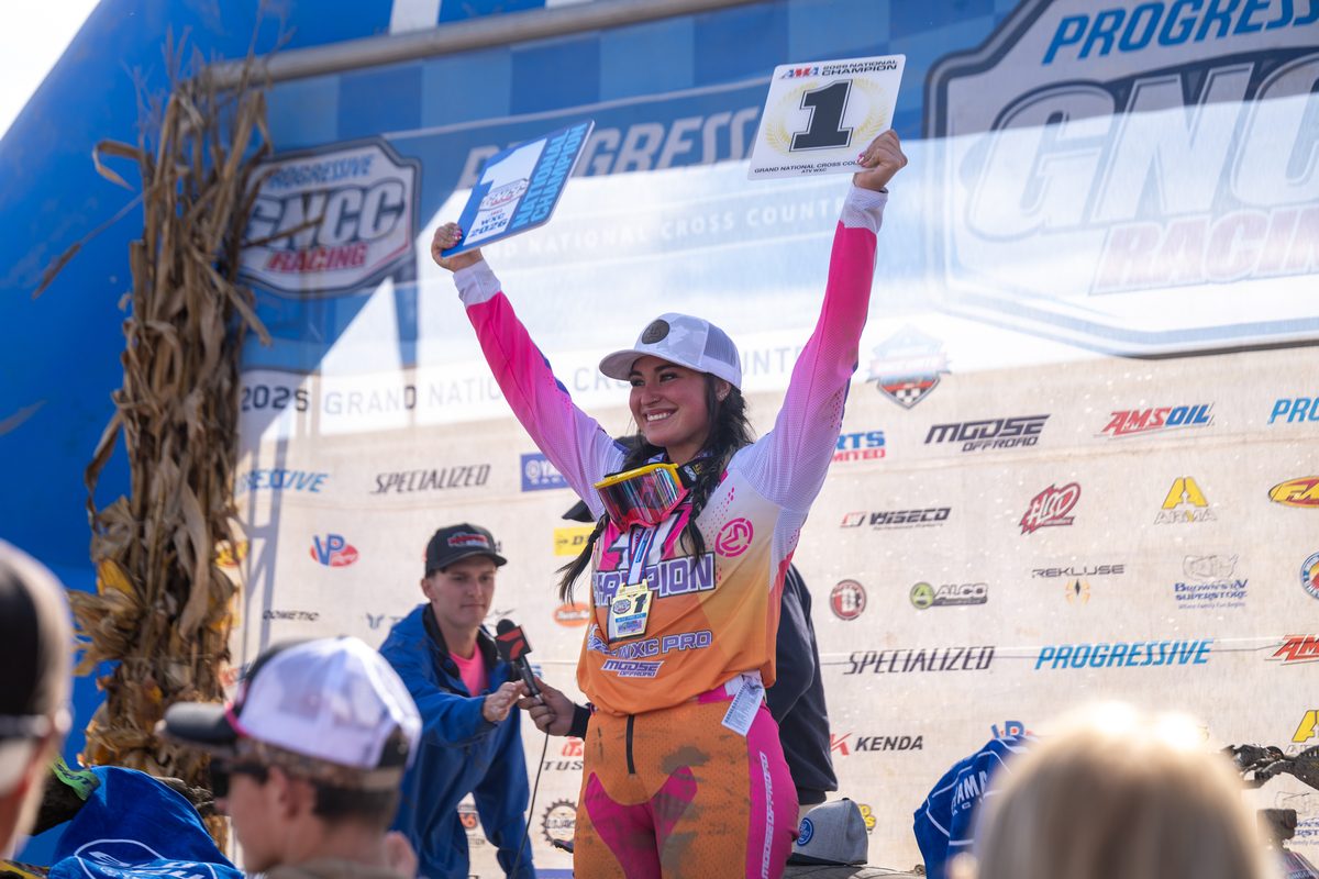 Chloe Harper raises her championship plates on the Ironman GNCC podium