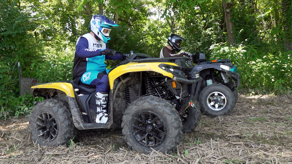 Kawasaki Brute Force 750 and Can-Am Outlander 700 launching side by side, with the Brute Force just ahead on the far side.